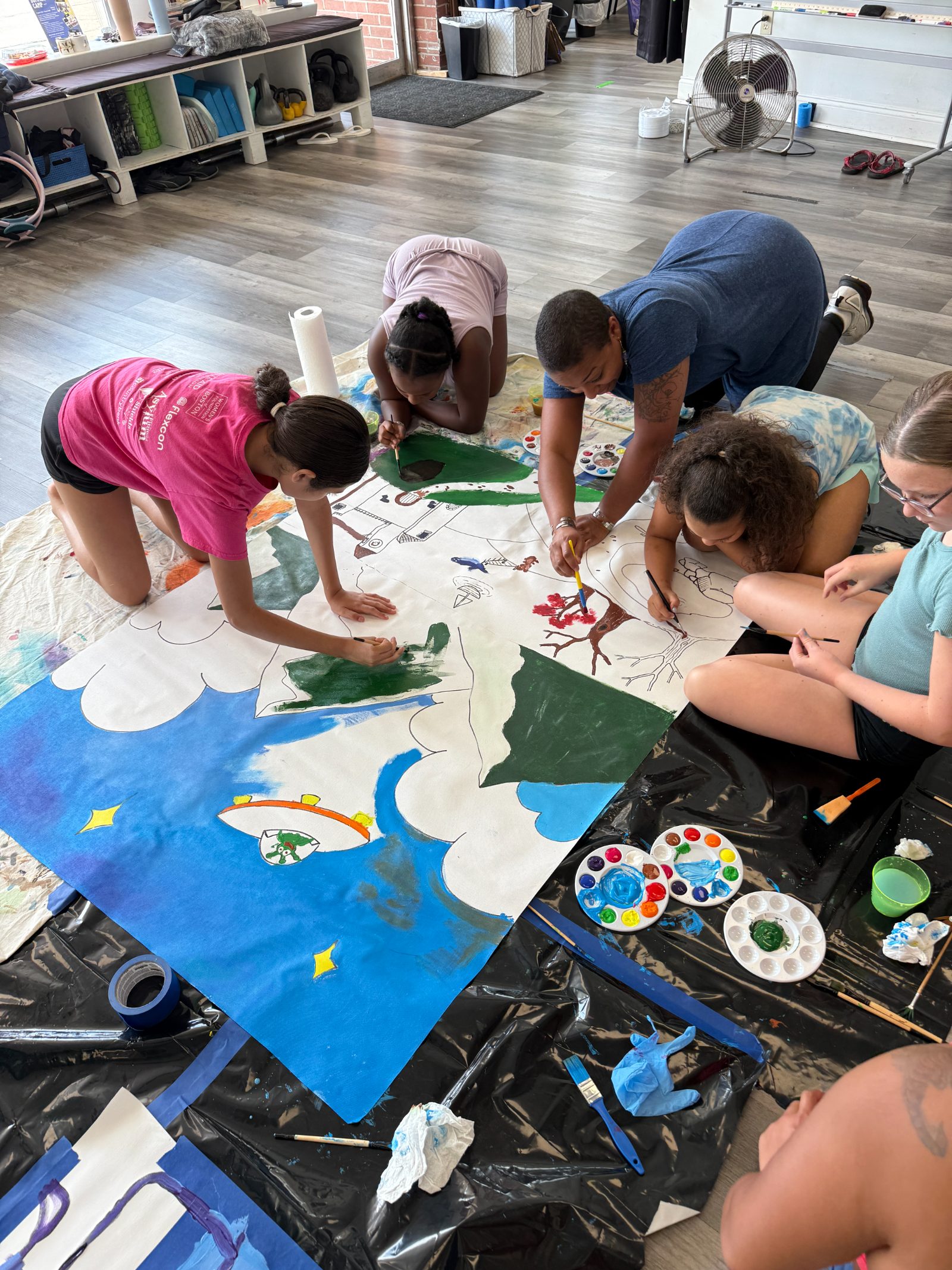 Kids painting a mural together at Agora summer camp